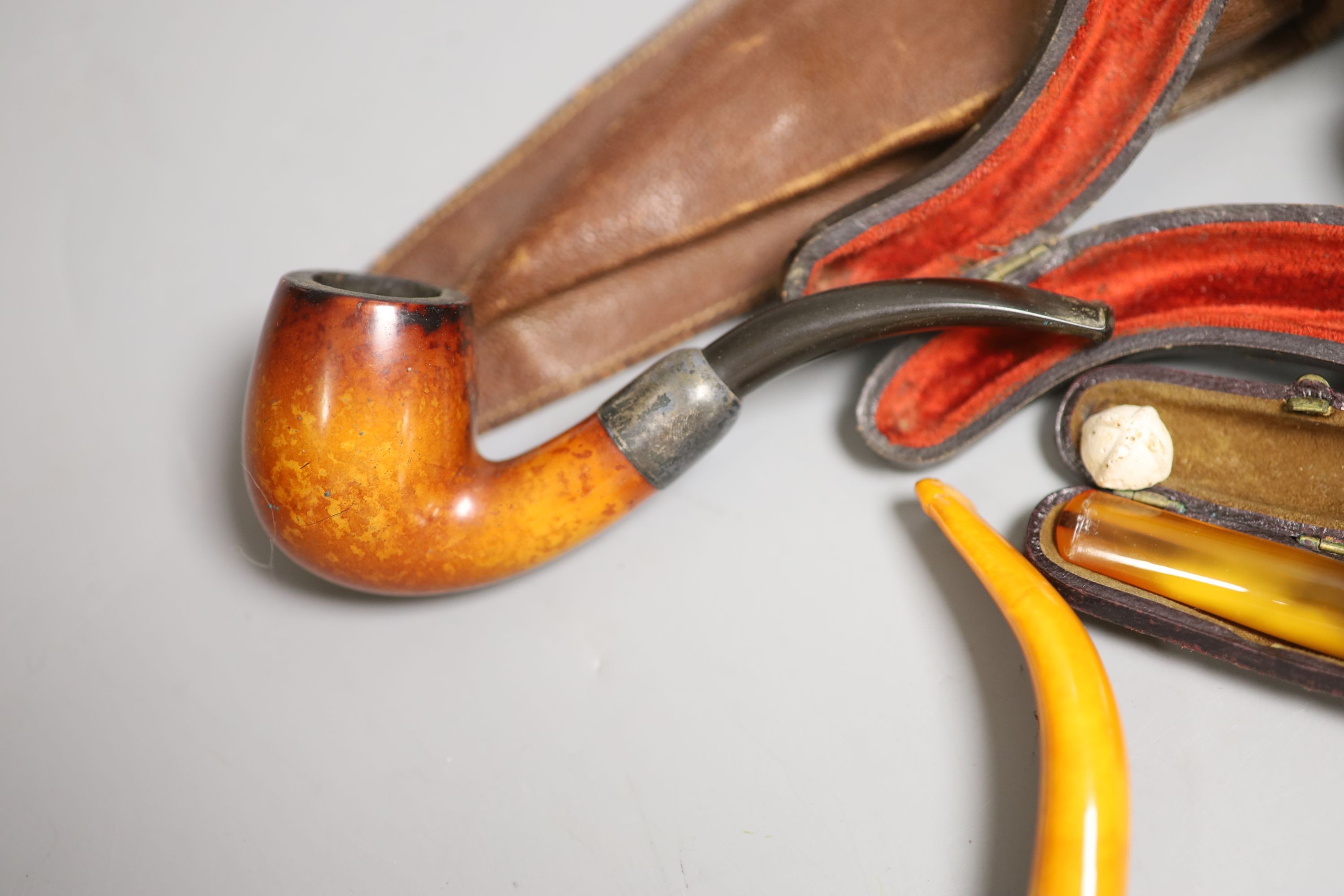 A Meerschaum and amber carved head (cased), 14.5cm long, an amber and gold cigarette holder and a wooden pipe